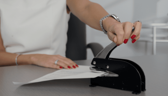 A woman stamping hoa documents for a house.