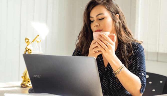 A homebuyer using her laptop to look up how much real estate agents make.