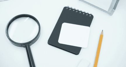 A magnifying glass and notebook to indicate an asbestos home inspection.