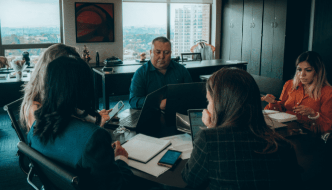 A group of people meeting to discuss HOA budget guidelines.