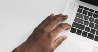 A person's hand as they look online at first time home buyer loans.
