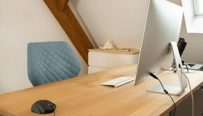 A desk and computer used to search for shopping for a house online.