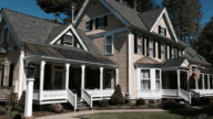 dos and don'ts when buying a home like this gray and white home with a wraparound porch