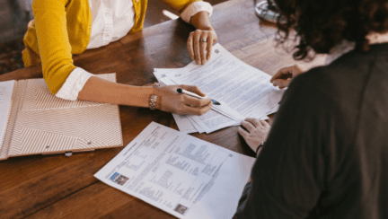 An agent and a homebuyer going over an exclusive contract with a real estate agent.