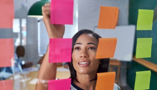 A real estate agent writing on a post-it.