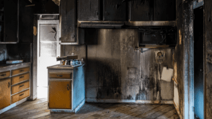 An oven that has had fire damage in a house.