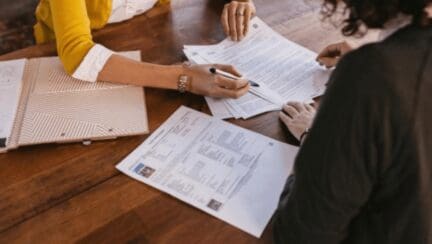 A realtor and client looking at a contract to buy an as is house.