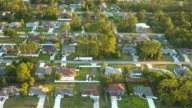 Aerial view of suburban landscape with private homes between green palm trees in Florida quiet residential area