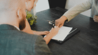 An image of a family signing documents to represent what a down payment is and how it works