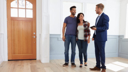 A couple and realtor during house walkthrough.